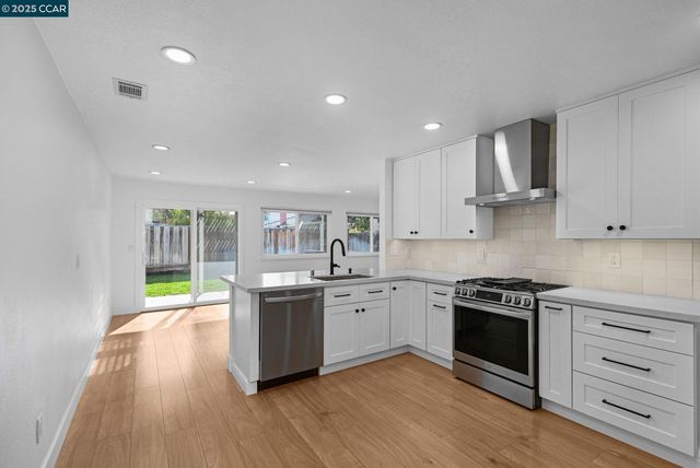 a kitchen with stainless steel appliances granite countertop a stove and cabinets