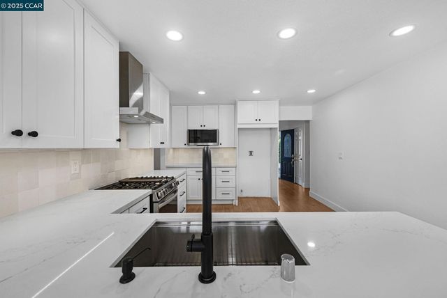 a kitchen with stainless steel appliances a refrigerator sink and microwave