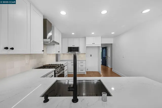 a kitchen with stainless steel appliances a refrigerator sink and microwave