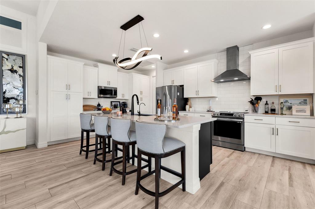 48 Master Drive Placida, FL 33946 - Photo 13 of 61 a kitchen with stainless steel appliances kitchen island granite countertop a wooden floor and white cabinets
