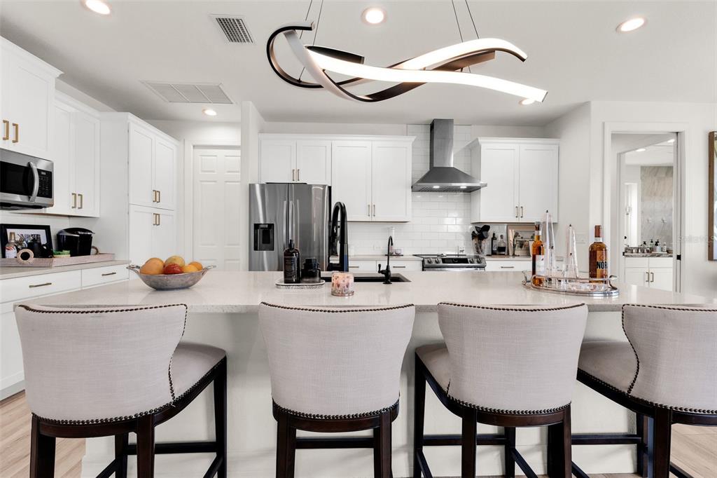 48 Master Drive Placida, FL 33946 - Photo 15 of 61 a kitchen with stainless steel appliances a stove a refrigerator and a dining table with white cabinets