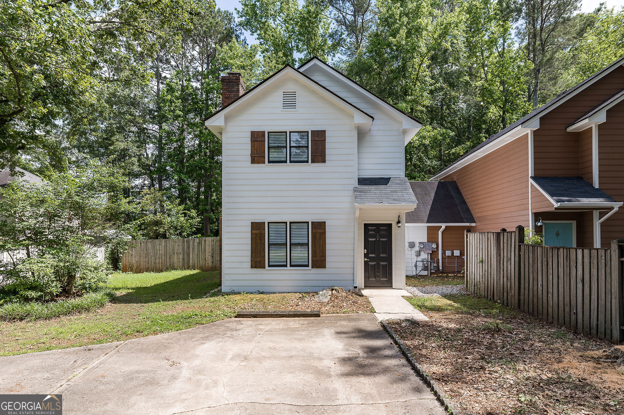 a view of a yard in front of a house with large windows