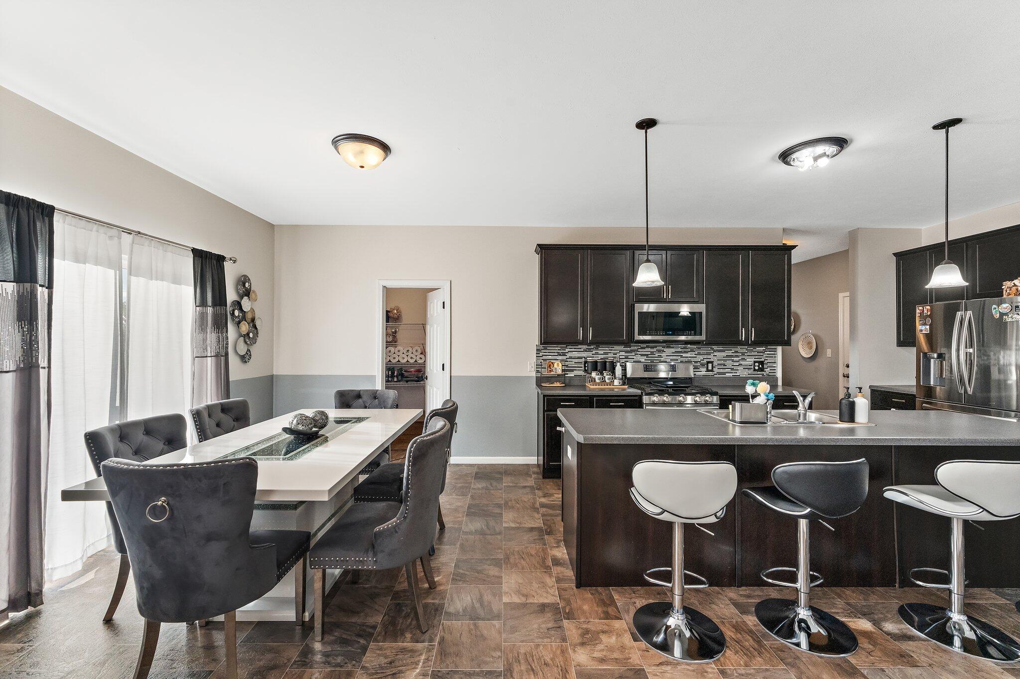 11539 Georgia Place Crown Point, IN 46307 - Photo 12 of 37 a kitchen with a dining table chairs and refrigerator