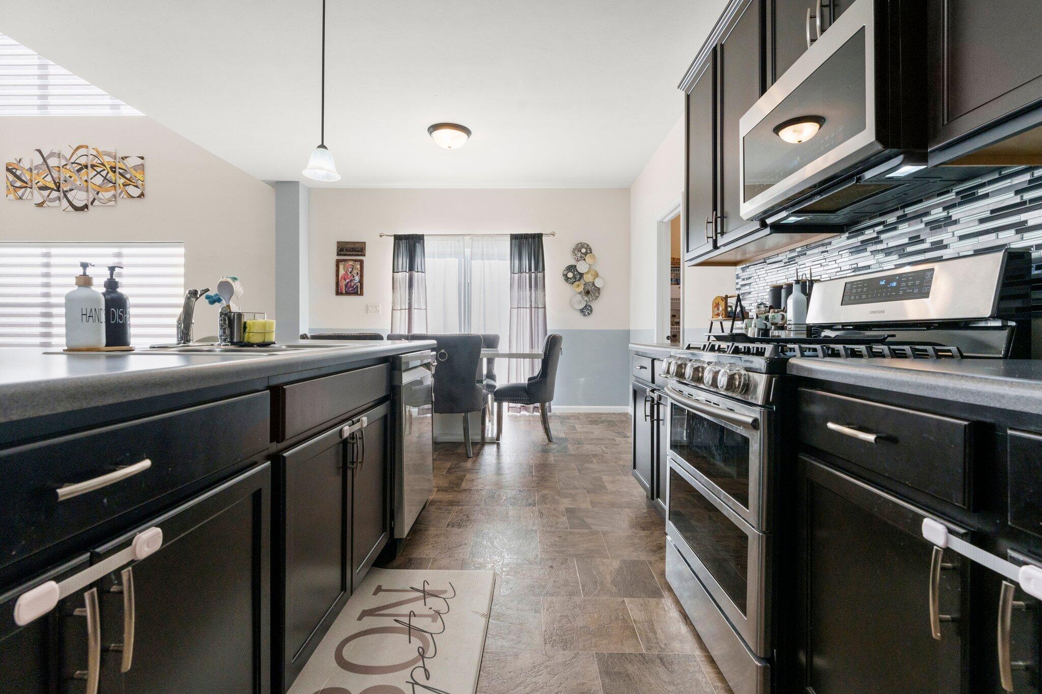 11539 Georgia Place Crown Point, IN 46307 - Photo 16 of 37 a kitchen with stainless steel appliances a stove a sink dishwasher and cabinets
