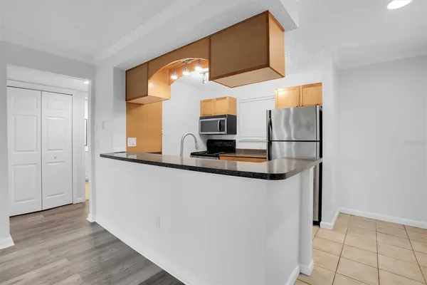 a kitchen with stainless steel appliances granite countertop a sink and a refrigerator