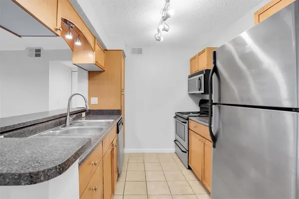 a kitchen with granite countertop a sink and a refrigerator