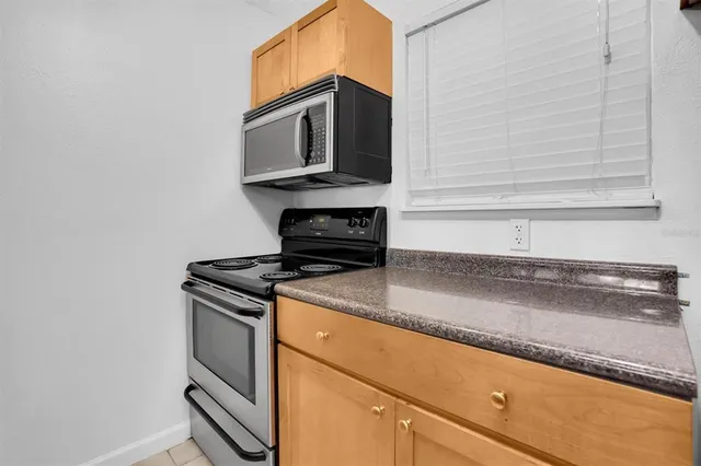 a kitchen with granite countertop cabinets stainless steel appliances and a counter space