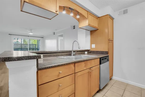 a kitchen with granite countertop cabinets stainless steel appliances and a counter space