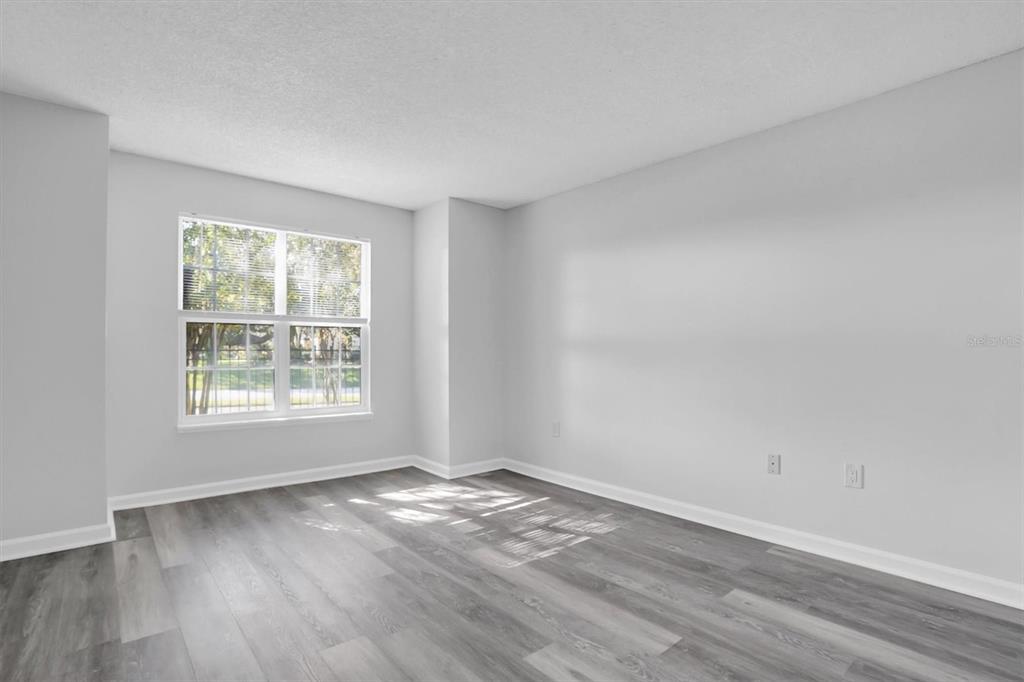 2500 Winding Creek Boulevard, Unit A104 Clearwater, FL 33761 - Photo 14 of 31 an empty room with wooden floor and windows