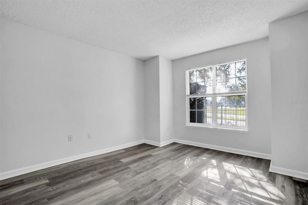 2500 Winding Creek Boulevard, Unit A104 Clearwater, FL 33761 - Photo 15 of 31 an empty room with wooden floor and windows