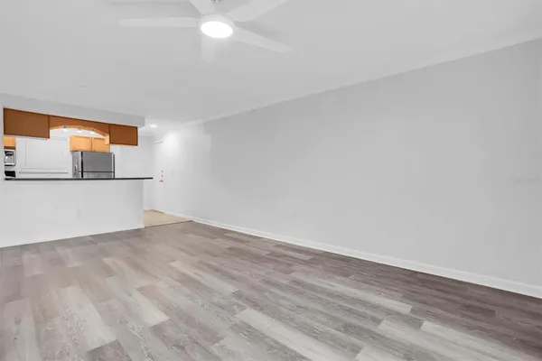 a view of a big room with wooden floor and windows