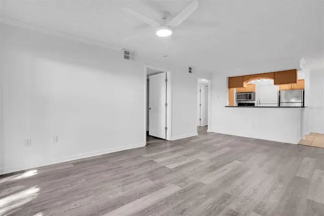 a view of a big room with wooden floor and windows