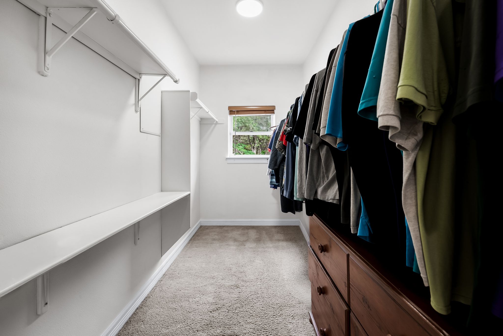 200 Vista West Ranch Road Dripping Springs, TX 78620 - Photo 11 of 20 Walk-in closet featuring built-in shelving, wall-mounted hanging rods, and a window providing natural light