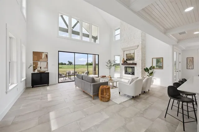 a living room with furniture large window and a table
