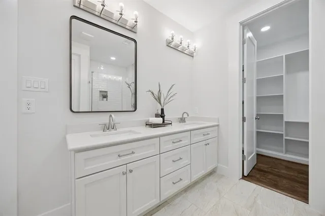 a bathroom with a double vanity sink and mirror