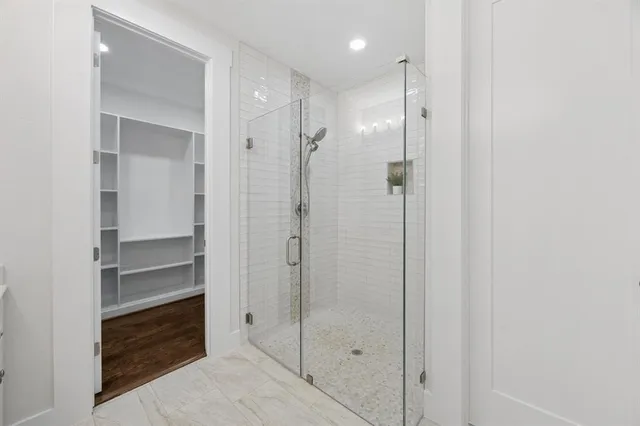 a bathroom with a shower and a glass door