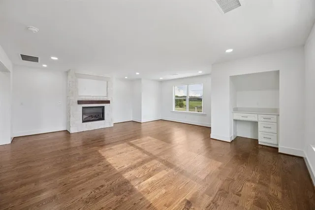 a view of an empty room with a window and fireplace