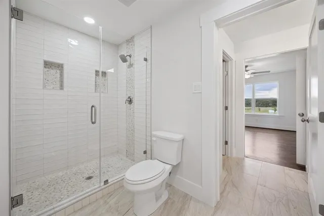 a bathroom with a toilet a sink and shower