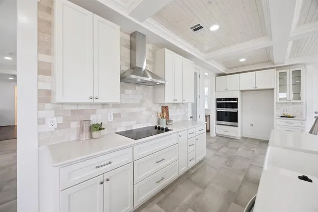 a kitchen with white cabinets and refrigerator