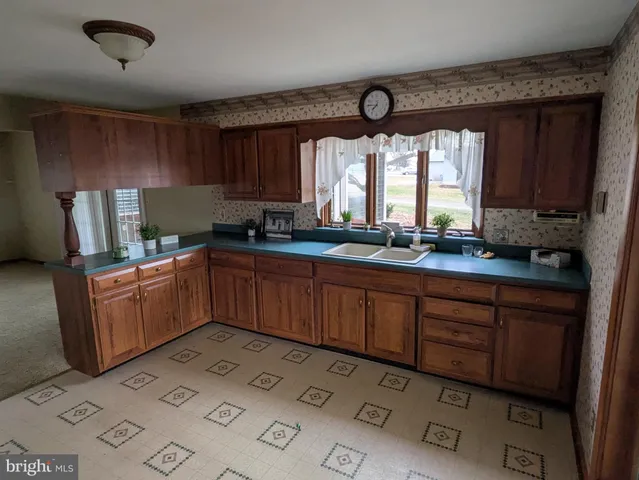 a kitchen with granite countertop a sink cabinets stainless steel appliances and a window