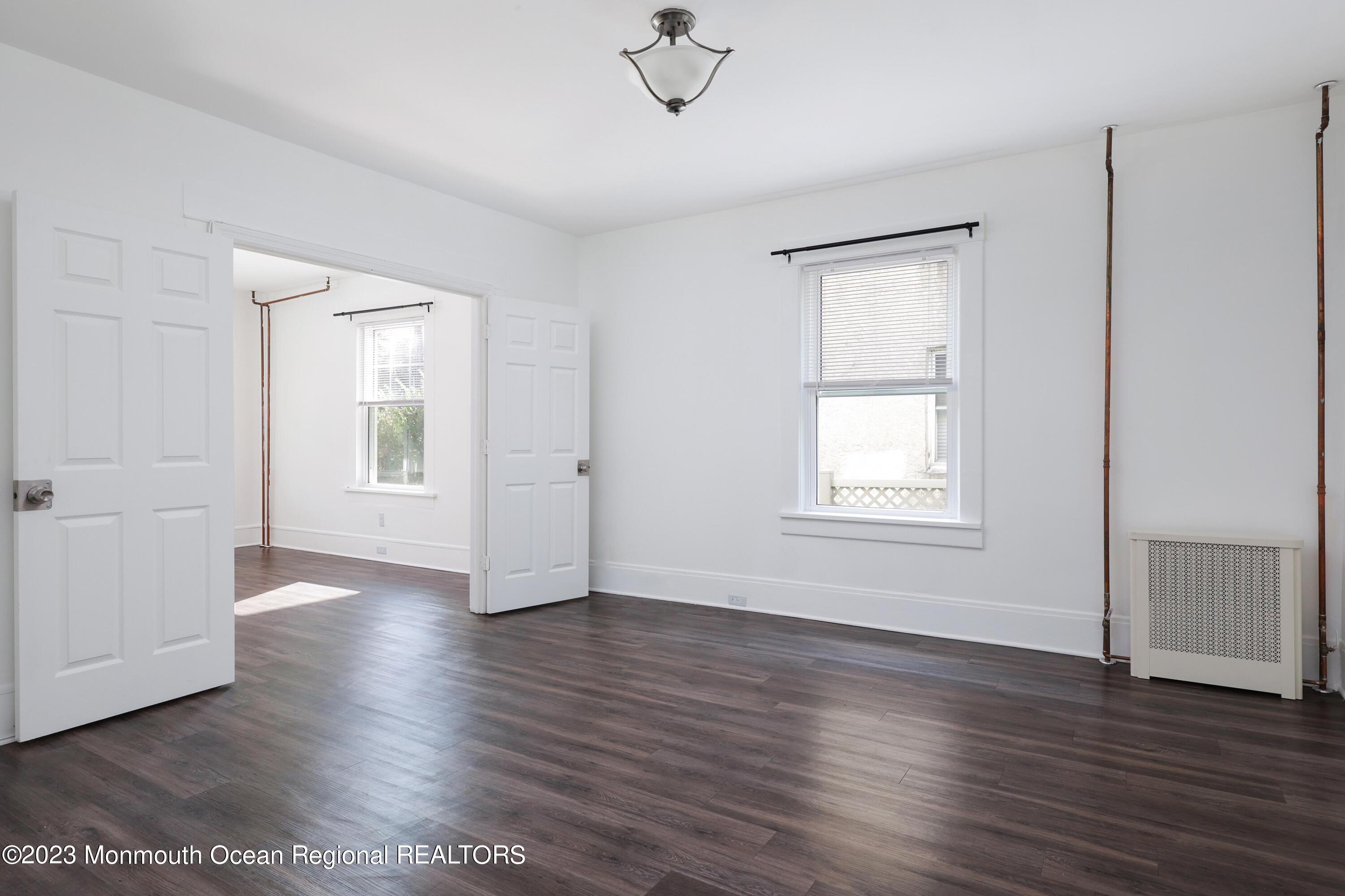 278 Broad Street, Unit FIRST Matawan, NJ 07747 - Photo 11 of 26 an empty room with wooden floor and windows