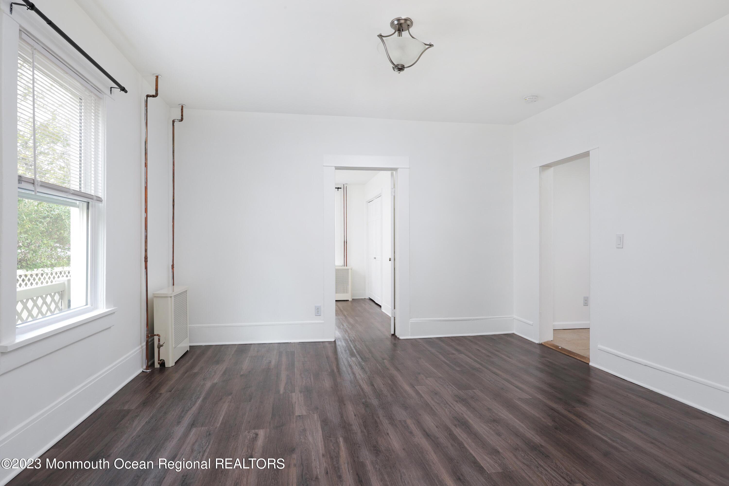 278 Broad Street, Unit FIRST Matawan, NJ 07747 - Photo 12 of 26 an empty room with wooden floor and windows