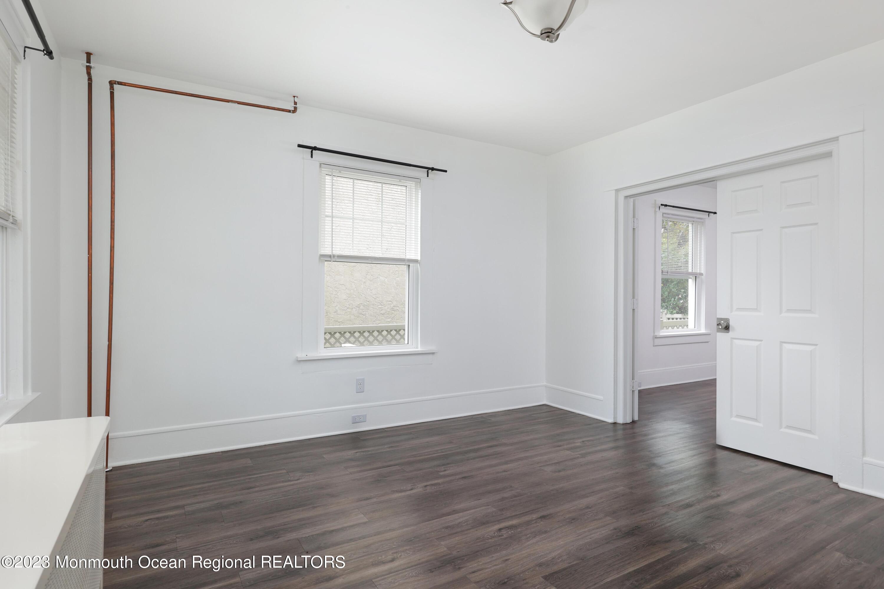 278 Broad Street, Unit FIRST Matawan, NJ 07747 - Photo 13 of 26 a view of an empty room with wooden floor and a window