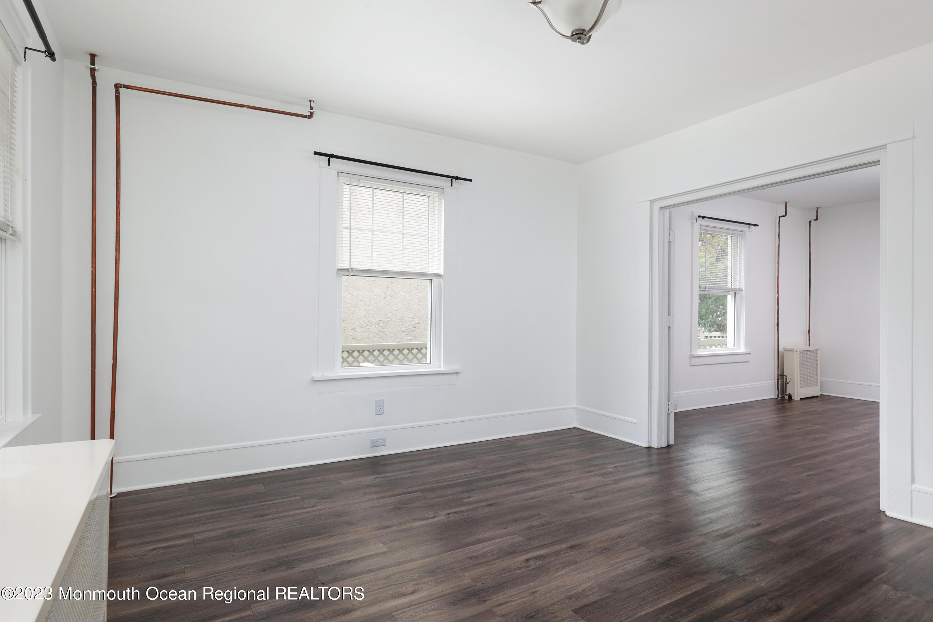 278 Broad Street, Unit FIRST Matawan, NJ 07747 - Photo 14 of 26 a view of an empty room with wooden floor and a window