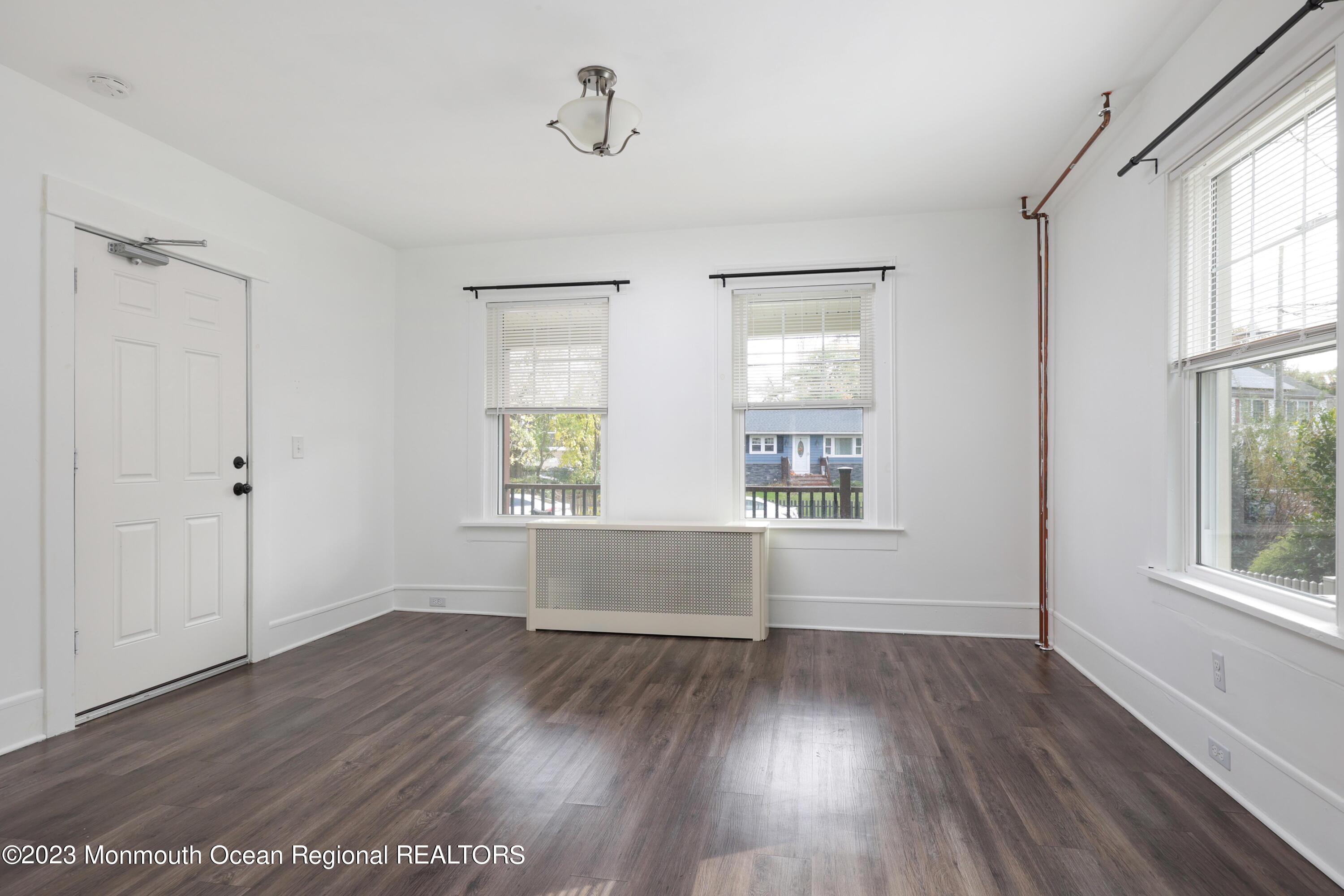 278 Broad Street, Unit FIRST Matawan, NJ 07747 - Photo 15 of 26 an empty room with wooden floor and windows
