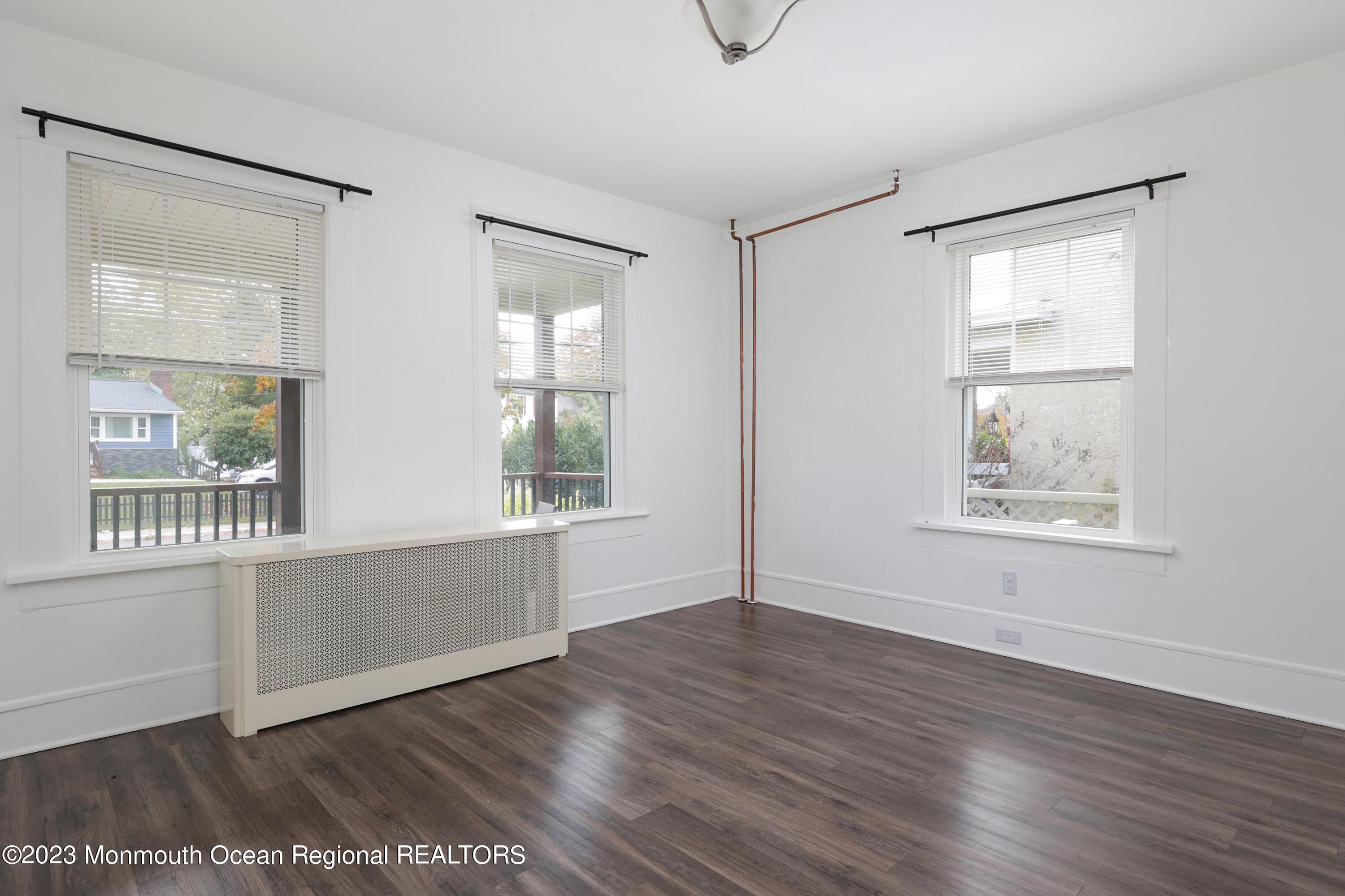 278 Broad Street, Unit FIRST Matawan, NJ 07747 - Photo 16 of 26 an empty room with wooden floor and windows
