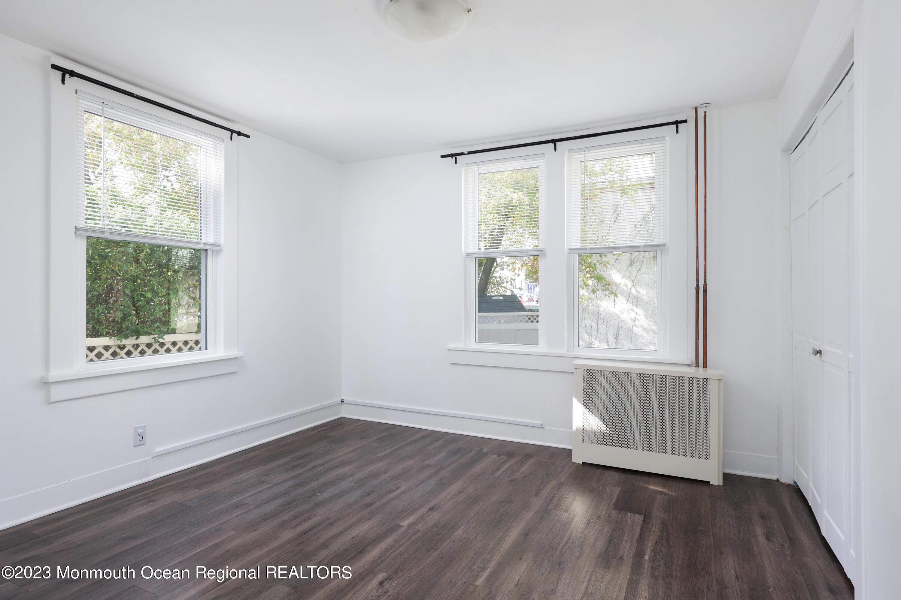 278 Broad Street, Unit FIRST Matawan, NJ 07747 - Photo 10 of 26 an empty room with wooden floor and windows