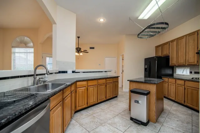 a kitchen with stainless steel appliances granite countertop a sink counter space cabinets and a large window