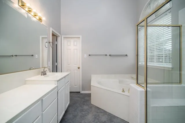 a bathroom with a tub sink and mirror