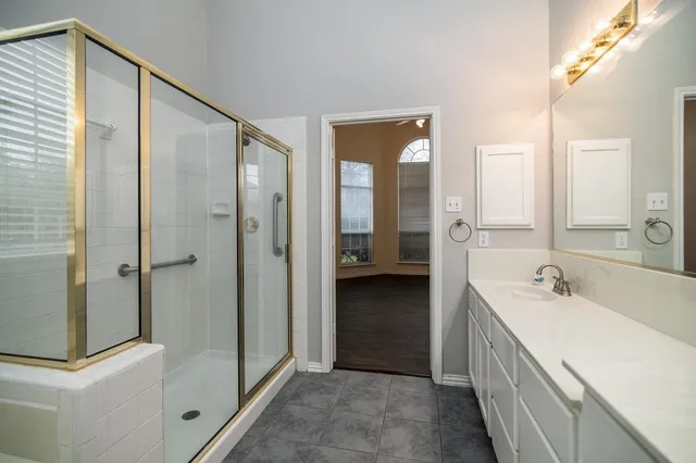 a bathroom with a double vanity sink and mirror with shower