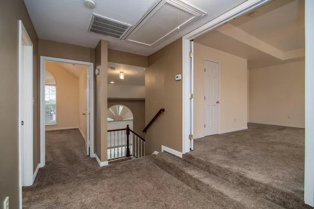 a view of a hallway to a livingroom with wooden floor and a ceiling fan