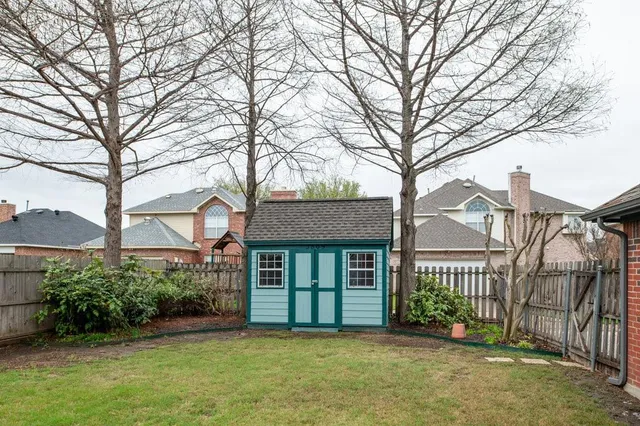 a view of a brick house with a large windows and a large tree
