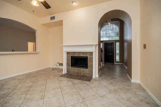 a view of an empty room with a fireplace and a window