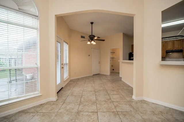 a view of a hallway with a chandelier fan and windows