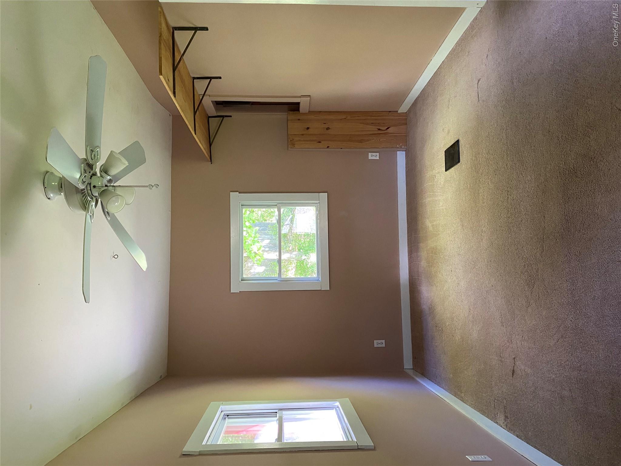 74 Lamoree Road Rhinebeck, NY 12572 - Photo 10 of 22 an empty room with windows and fan