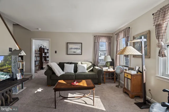 a living room with furniture a flat screen tv and a window
