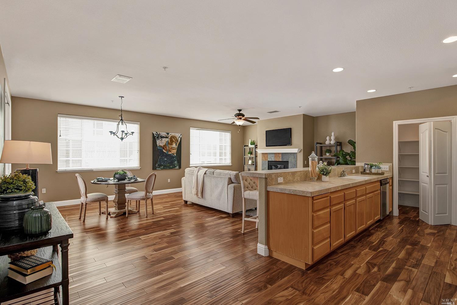 a large white kitchen with wooden floors and stainless steel appliances