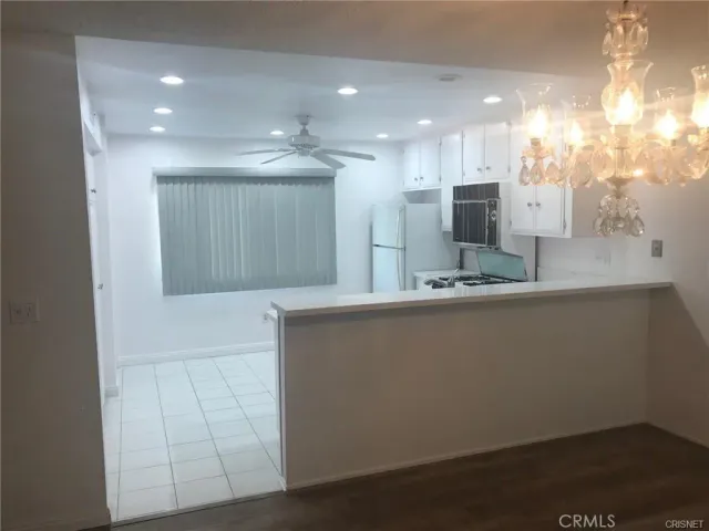 an empty room with wooden floor fireplace and windows