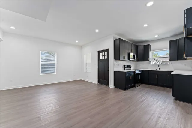 a kitchen with stainless steel appliances kitchen island wooden cabinets a stove a sink and a refrigerator