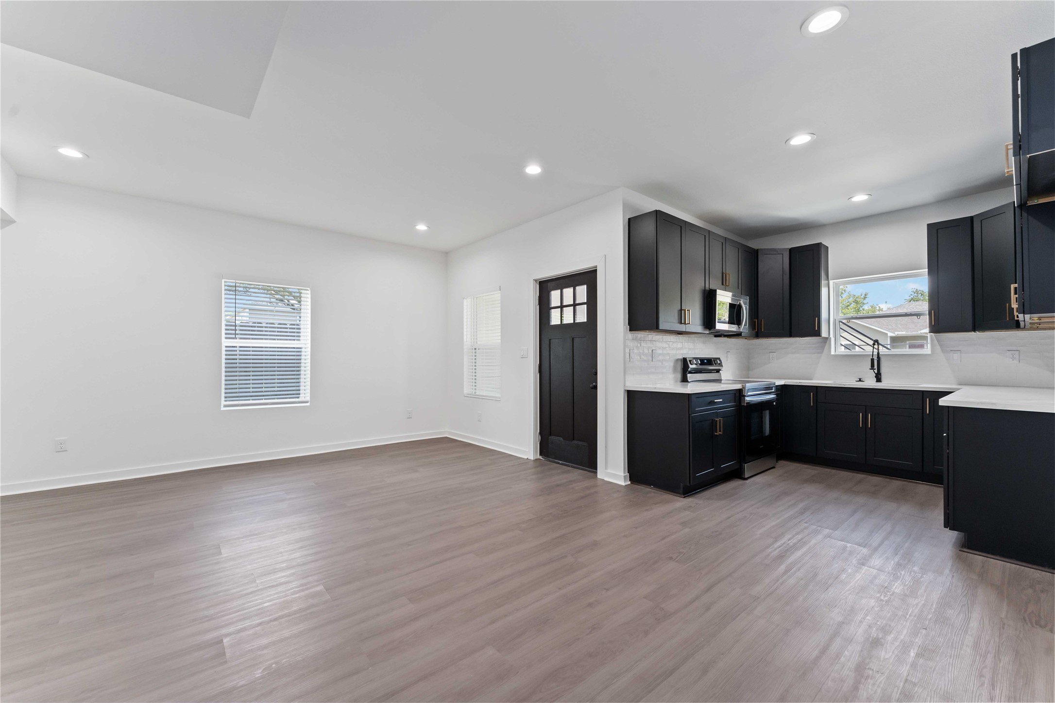 414 North Carolina Street, Unit A Houston, TX 77029 - Photo 6 of 25 a kitchen with stainless steel appliances kitchen island wooden cabinets a stove a sink and a refrigerator