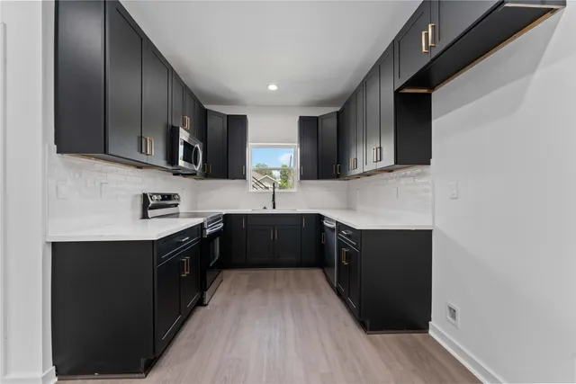 a kitchen with stainless steel appliances granite countertop a sink stove and refrigerator