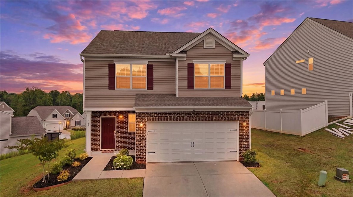 365 Sliding Rock Drive Pendleton, SC 29670 - Photo 43 of 46 A classic facade with a single garage door, set against a vibrant twilight sky.