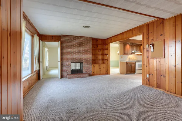 a view of an empty room with a fireplace and a window