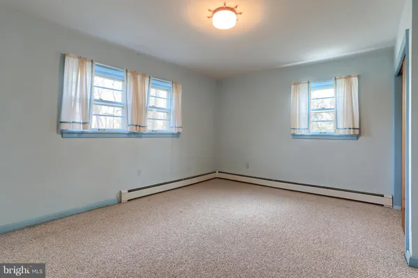 an empty room with windows and closet