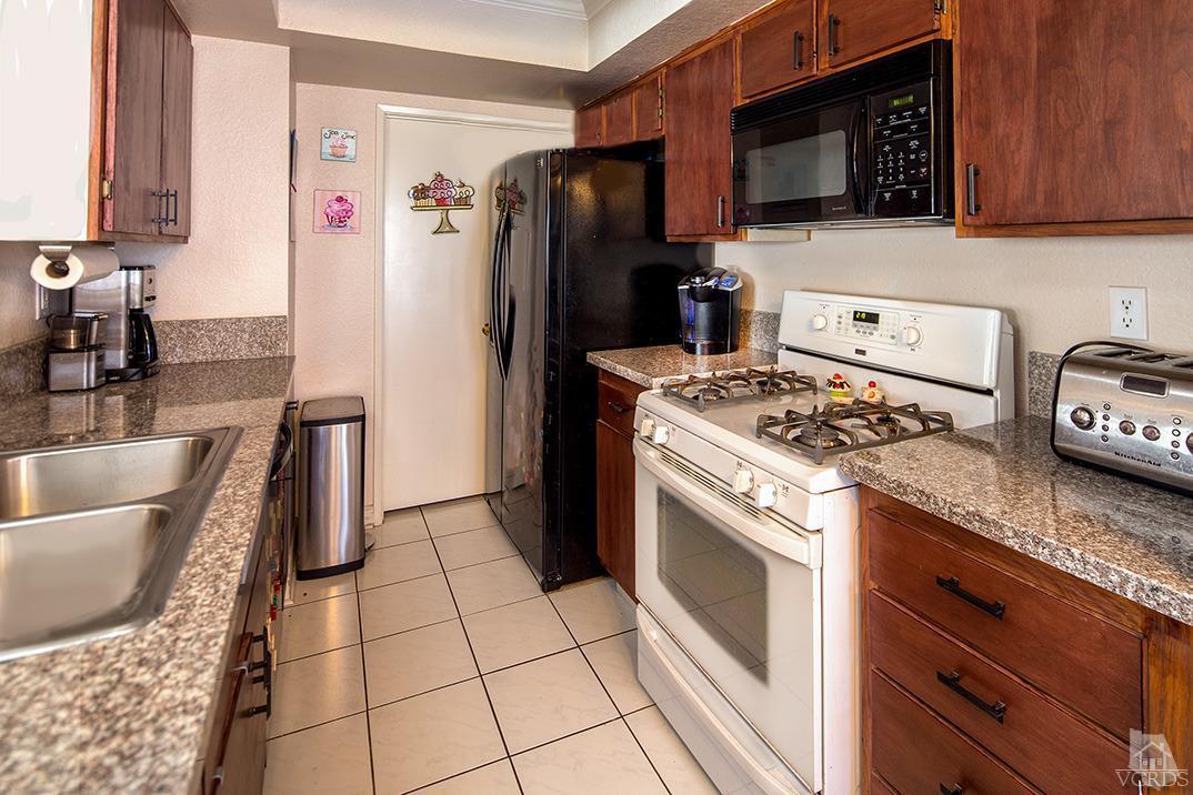1175 Fitzgerald Road, Unit A Simi Valley, CA 93065 - Photo 5 of 16 a kitchen with granite countertop a stove and a refrigerator