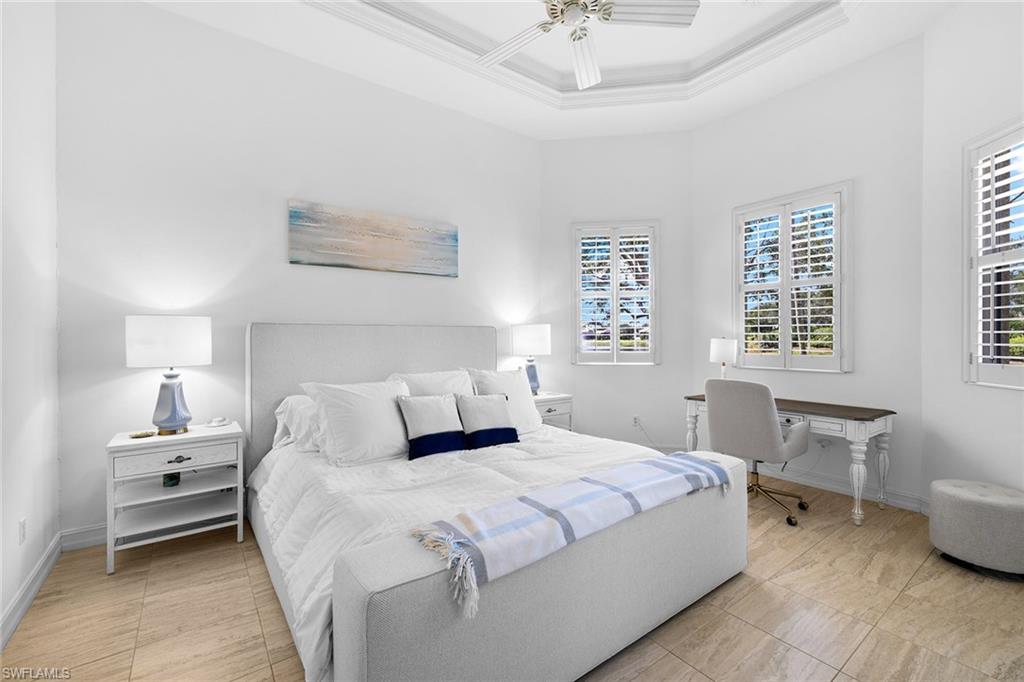 7785 Ashton Road Naples, FL 34113 - Photo 15 of 39 a bedroom with a bed and a table chair